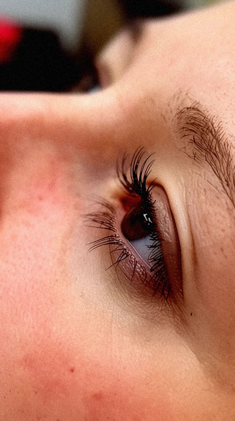 Primer plano de ojo femenino con pestañas largas y definidas, piel natural y textura visible, mostrando detalle de mirada tras tratamiento estético en salón de belleza en Alcantarilla (Murcia).